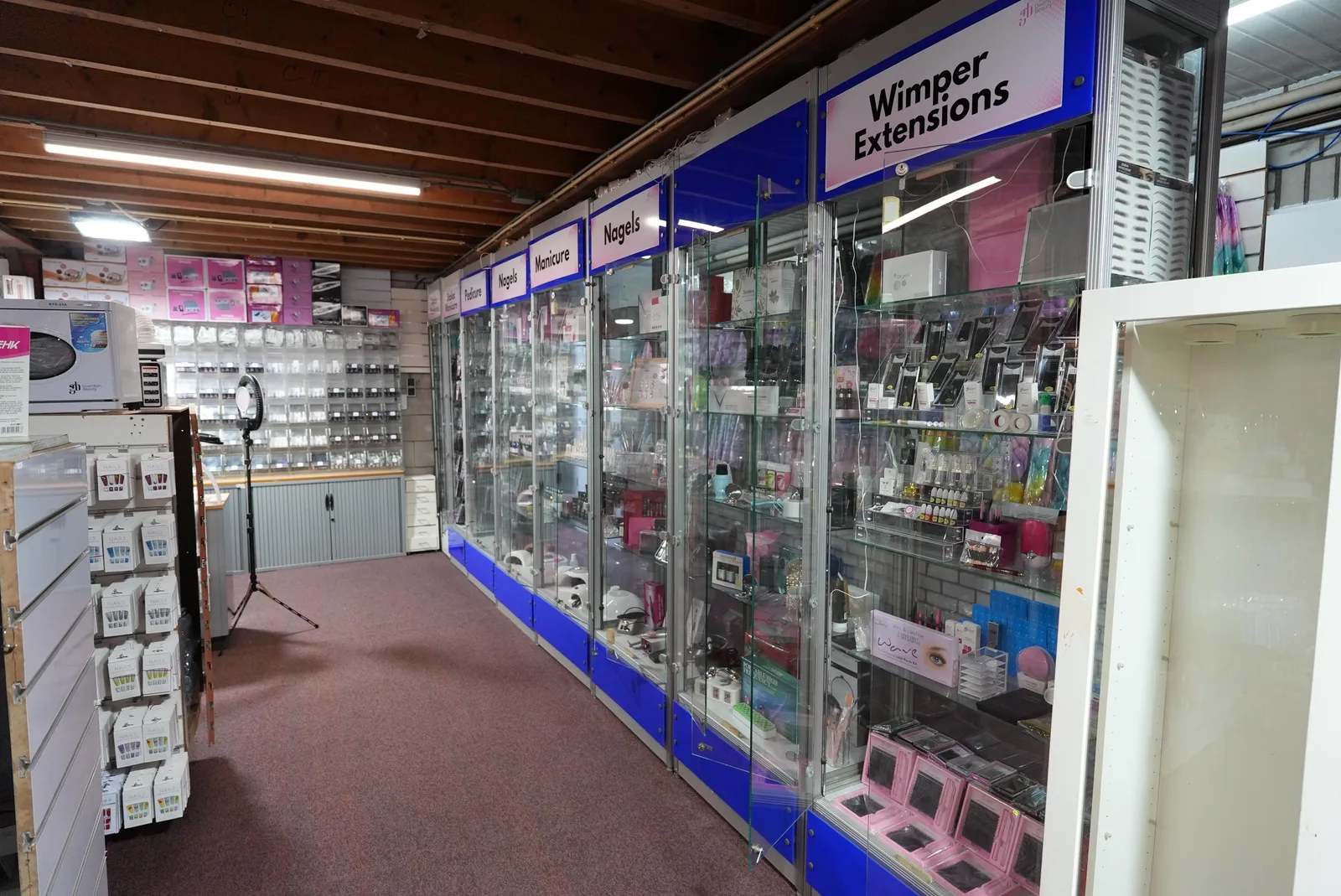 Vitrines met nagelproducten en wimperextensions in de showroom